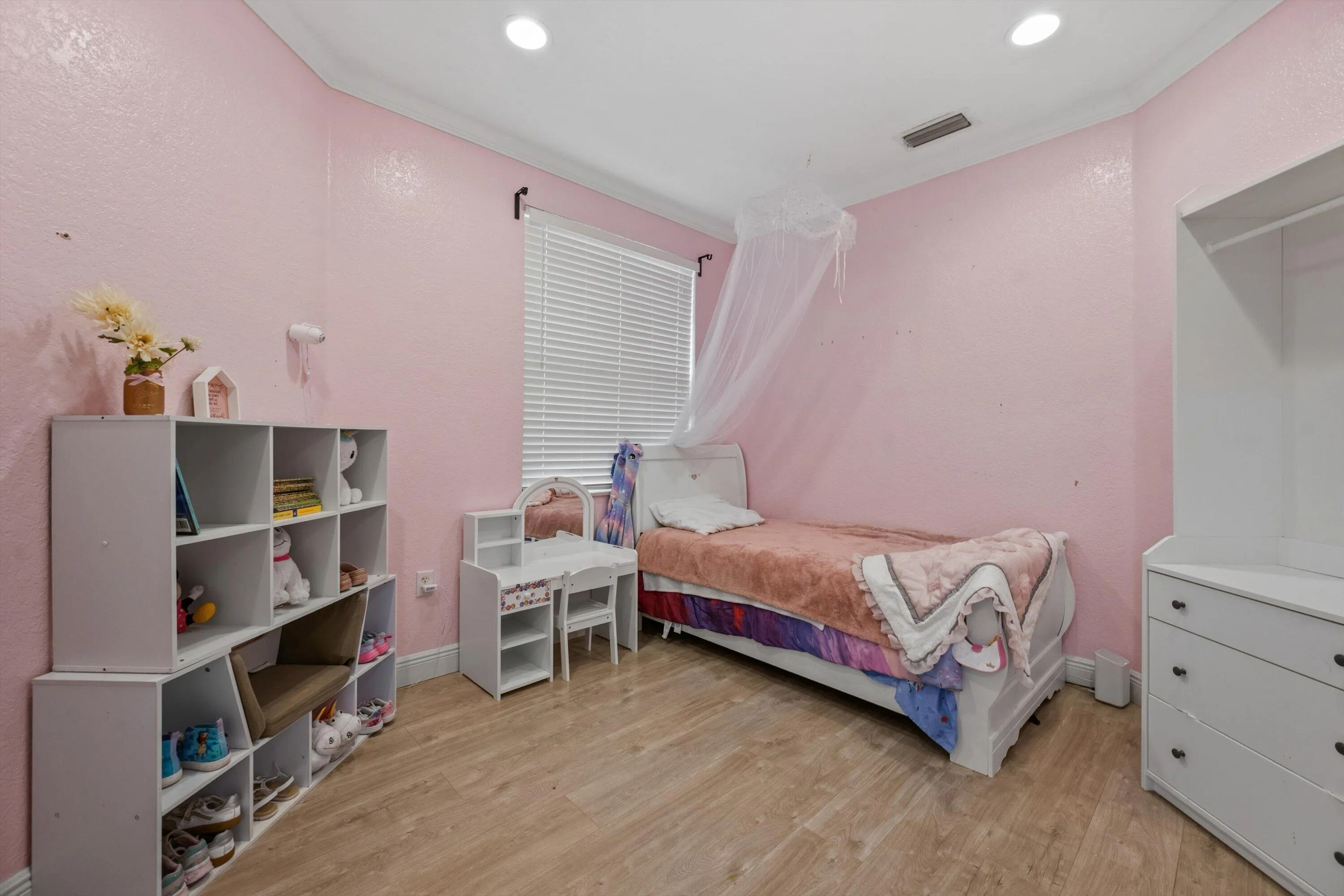 Bright interior space featuring wood-finish flooring, recessed lighting, and a window with horizontal blinds