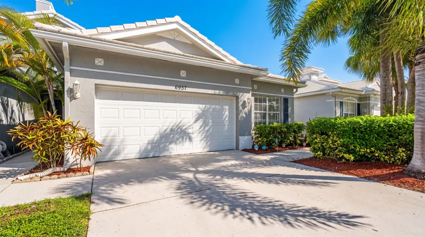 Front exterior featuring a white paneled garage door, an asphalt shingle roof, and a concrete driveway
