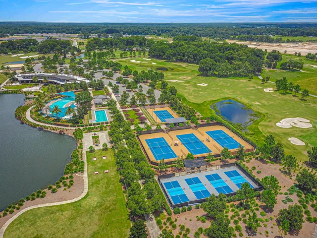 Expansive property featuring a large contemporary-style building, multiple manicured green spaces, and a prominent water feature