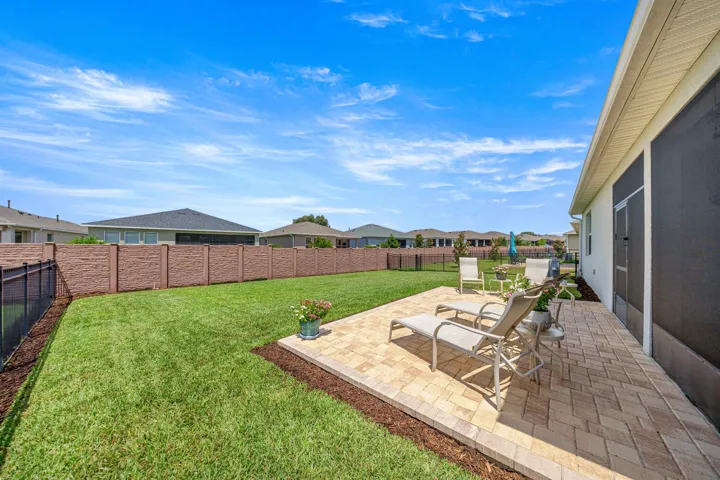 Expansive green lawn with a concrete patio area