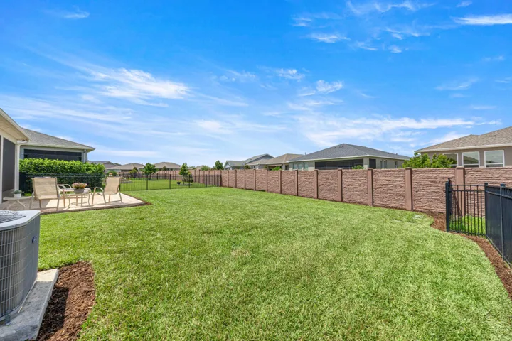 Expansive green lawn with a concrete patio area