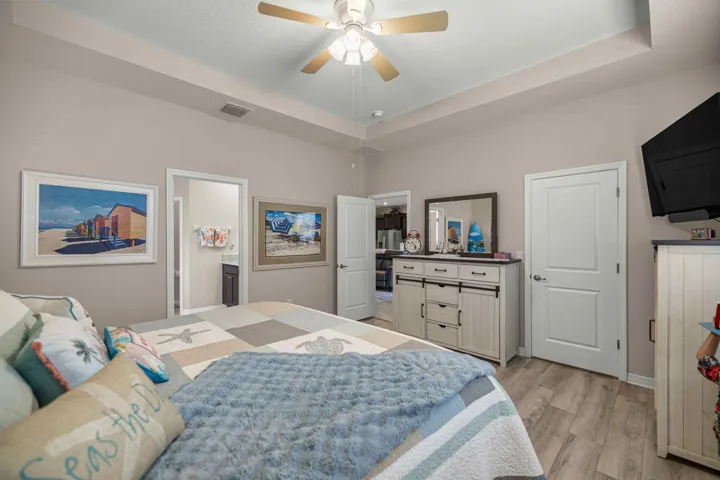 Bedroom featuring a tray ceiling with a ceiling fan