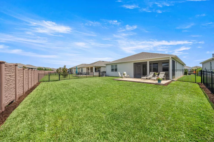 Expansive green lawn with a concrete patio area
