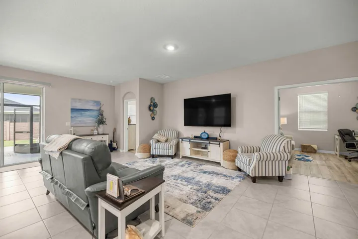 Spacious living area featuring large format floor tiles and light wall tones