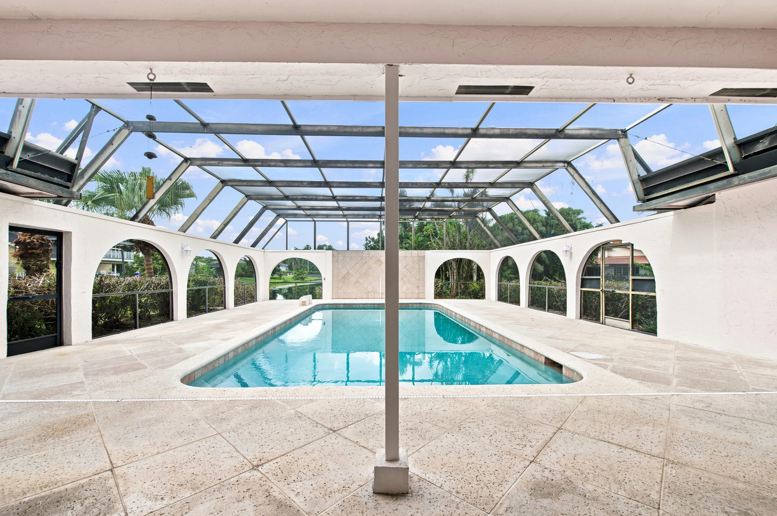 Screened swimming pool enclosure featuring a rectangular pool