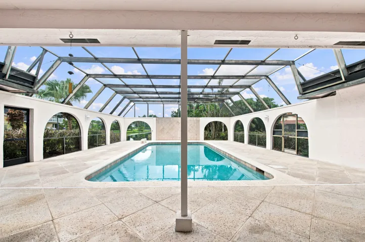 Screened swimming pool enclosure featuring a rectangular pool