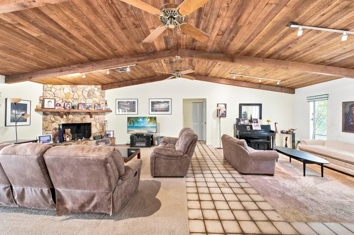 Vaulted wood-plank ceiling with exposed beams and ceiling fans