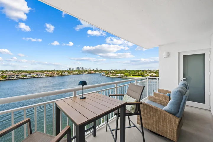 Spacious balcony featuring concrete flooring and white railing overlooking a waterway