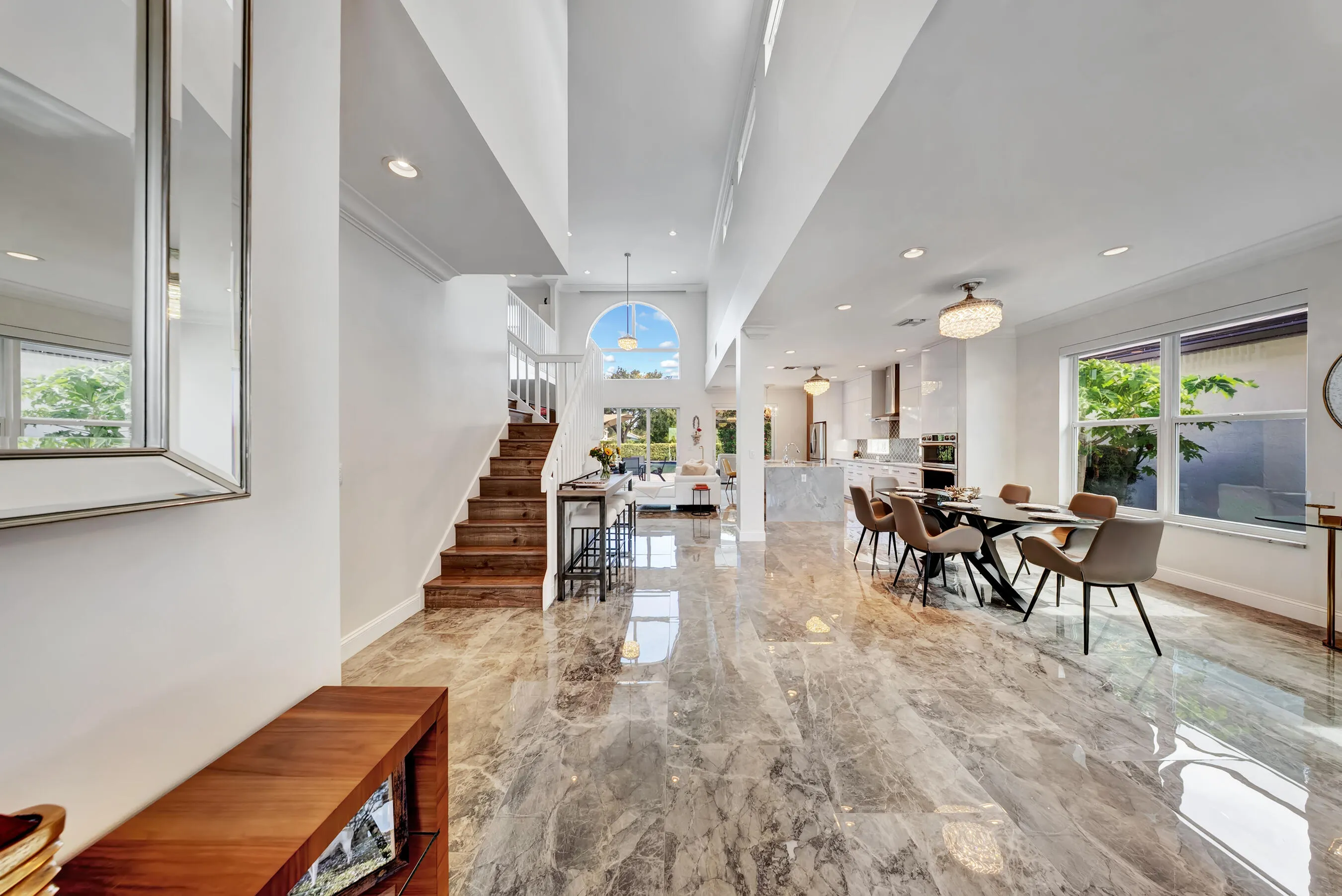 Entry hall with soaring ceilings opening to the great room, dining area, and chef's kitchen beyond.