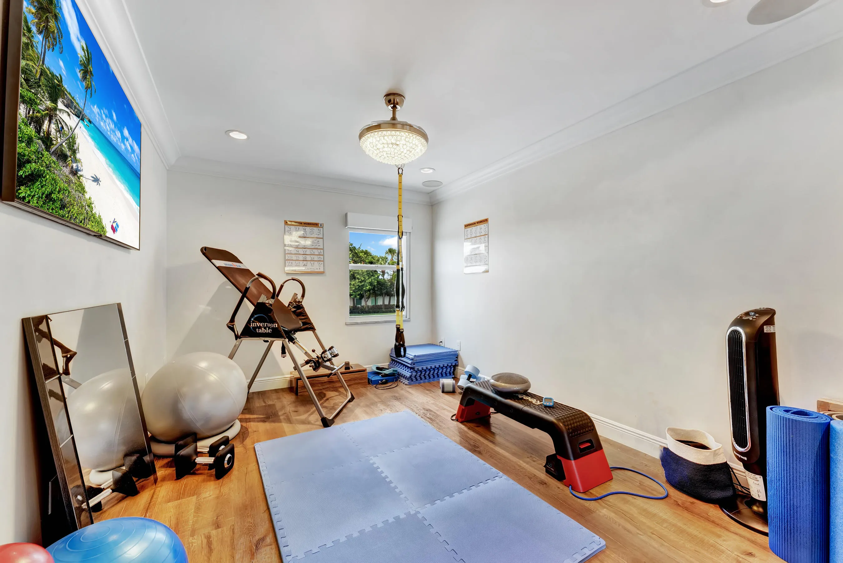 Bedroom 3 currently used as a home gym, with wood floors and dual windows.