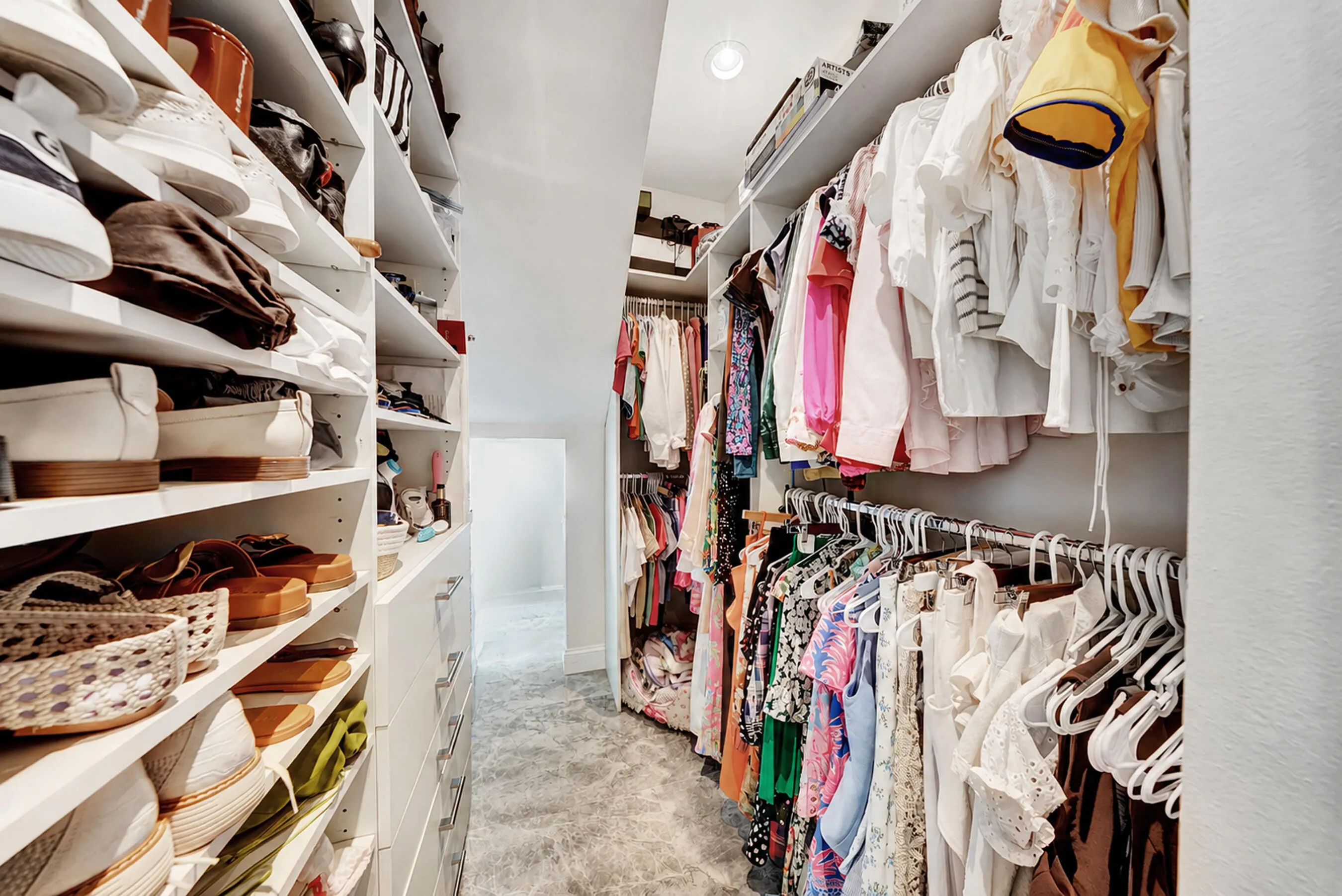 Second custom walk-in closet with floor-to-ceiling organized hanging and shelf systems.