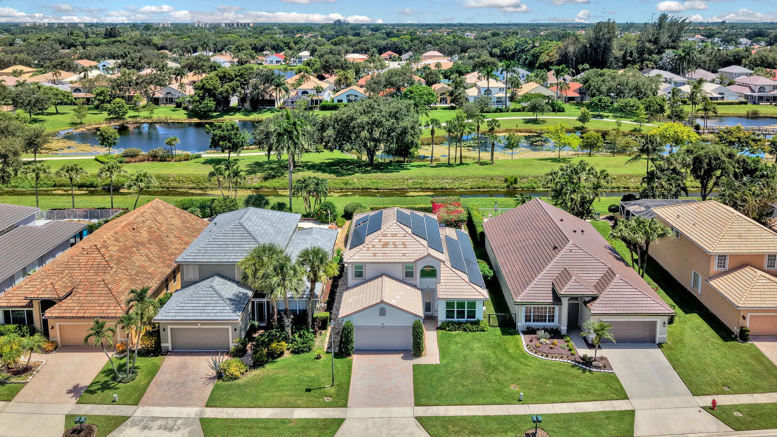 Daytime aerial of the home and surrounding streetscape in the gated Polo Trace community of Delray Beach, Florida.