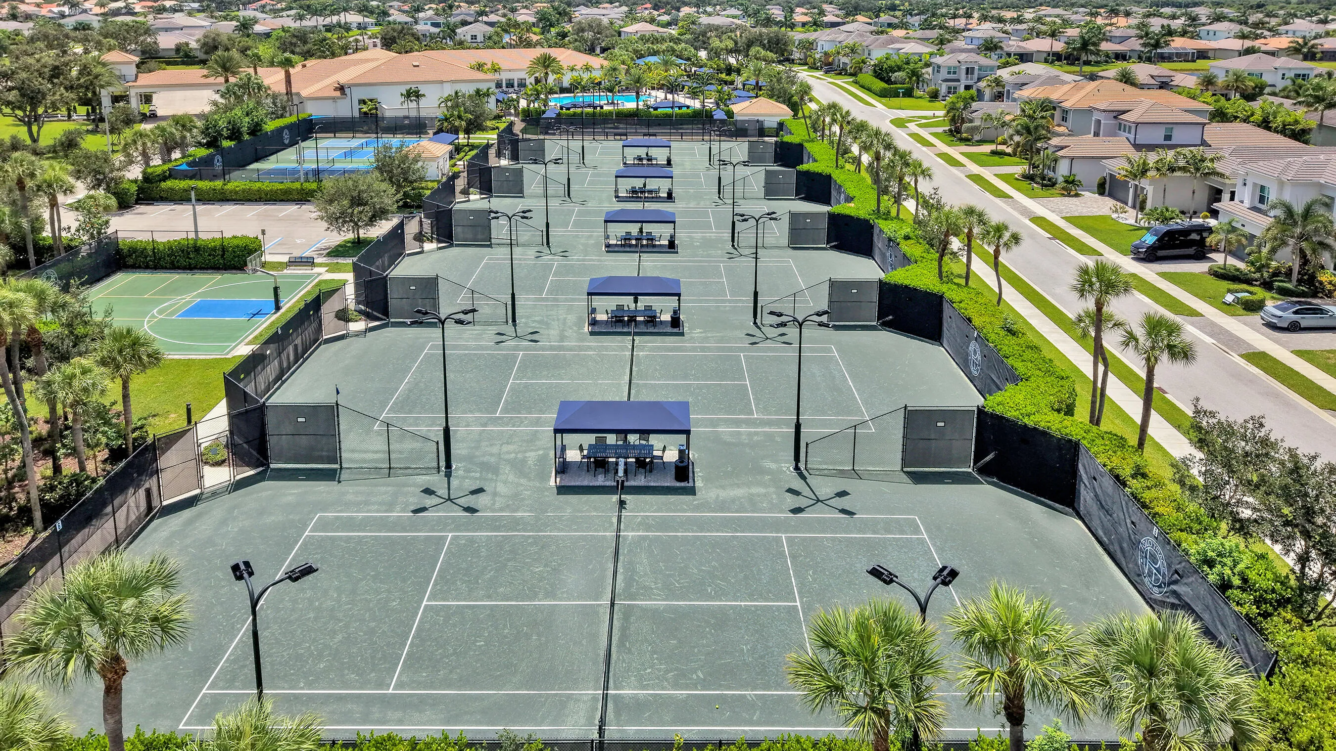 Polo Trace community tennis and pickleball complex with shaded pavilions, lighted courts, and basketball court.