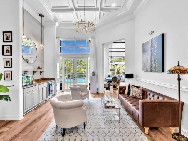 FORMAL LIVING ROOM WITH COFFERED CEILINGS, A WET BAR, WAINSCOTTING, WINE FRIDGE, SPECIALTY WINE DISPLAY AND SLIDING DOORS TO OUTSIDE AREA.