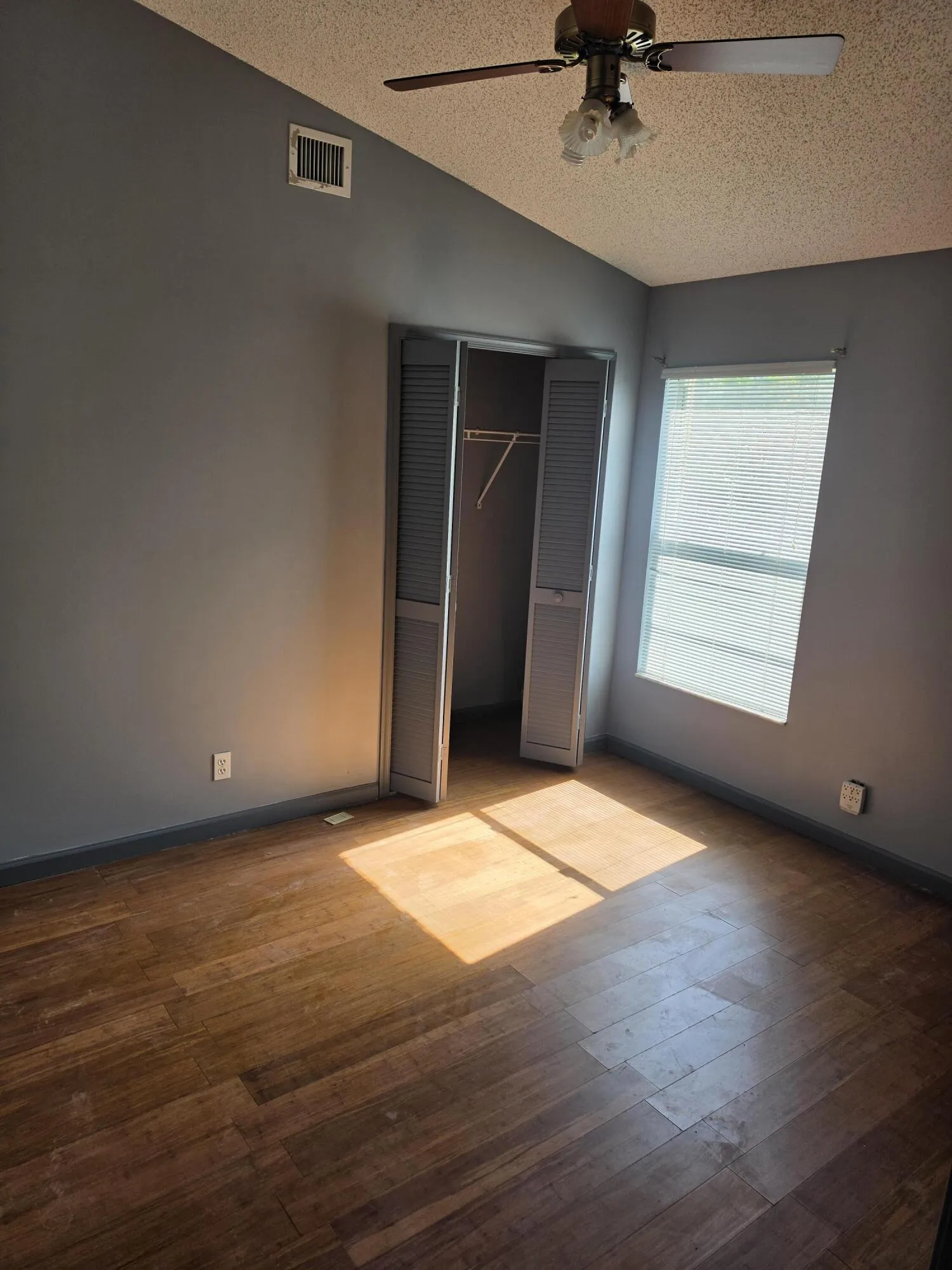 Wood-finish flooring complemented by a ceiling fan with integrated lighting