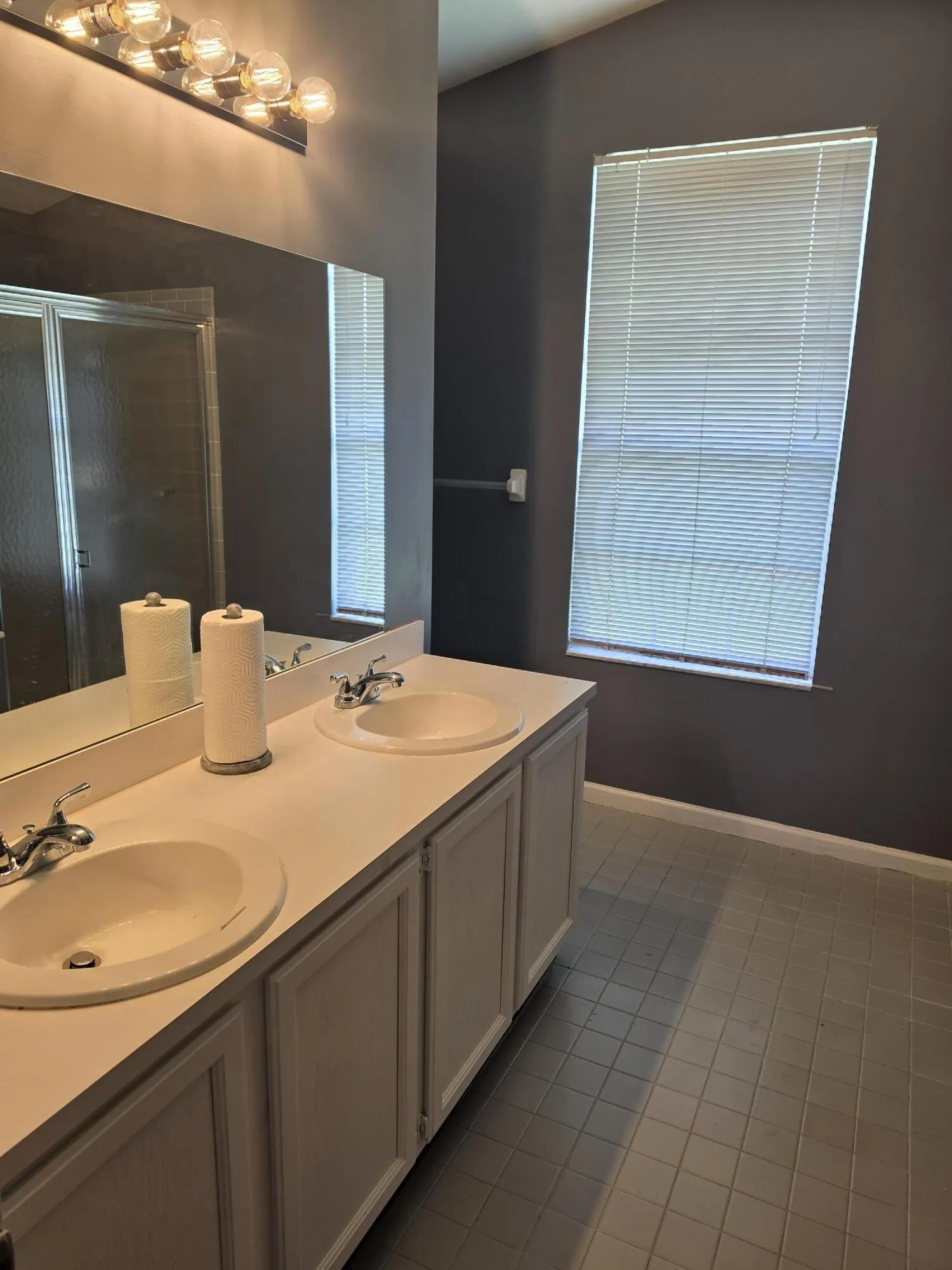 Double vanity with integrated sinks, brushed nickel faucets, and grey cabinet doors