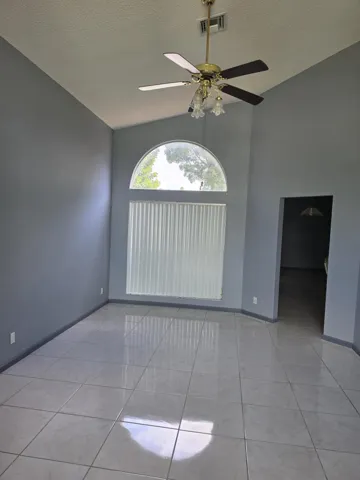 Vaulted ceiling featuring a brass-finish ceiling fan with integrated lighting
