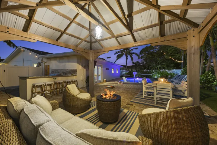 Gazebo with fire pit, pool and summer kitchen views.