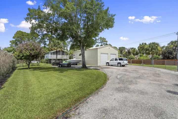 Expansive gravel driveway leading to a detached workshop