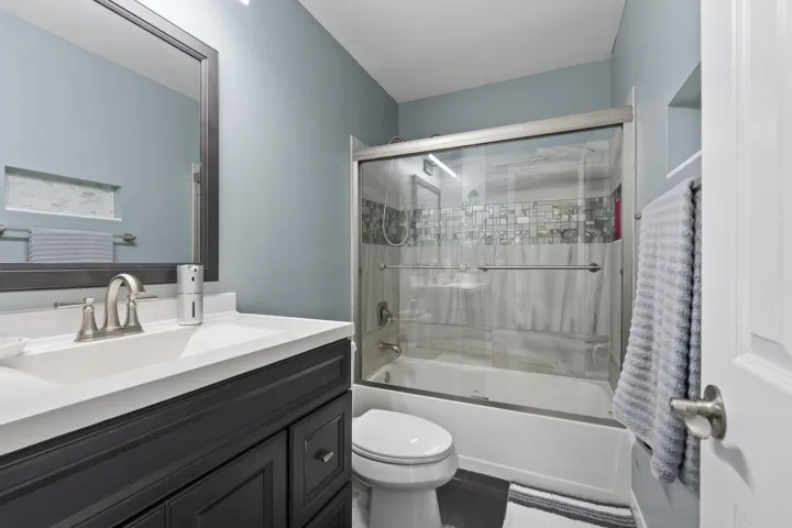 Bathroom featuring a dark wood-finish vanity with a white countertop and brushed nickel faucet
