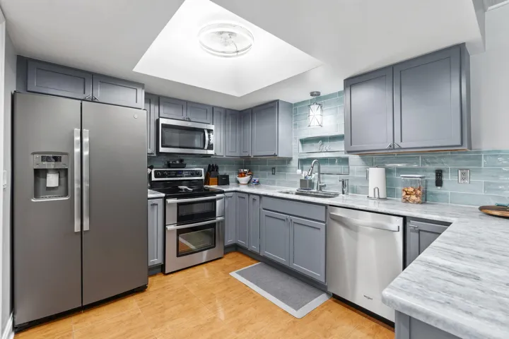 Stainless steel appliances including double oven range, tile flooring, granite countertops, tile backslash,