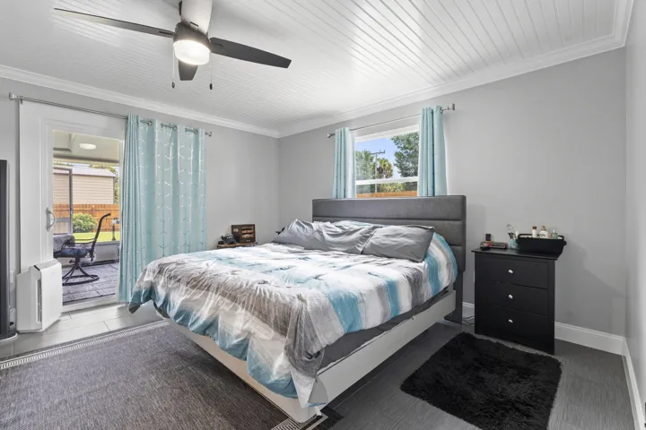 Bedroom with en-suite bathroom and sliding glass door leading to the back porch.