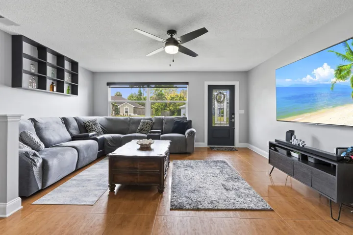 Spacious living area featuring tile flooring and large windows for natural light.