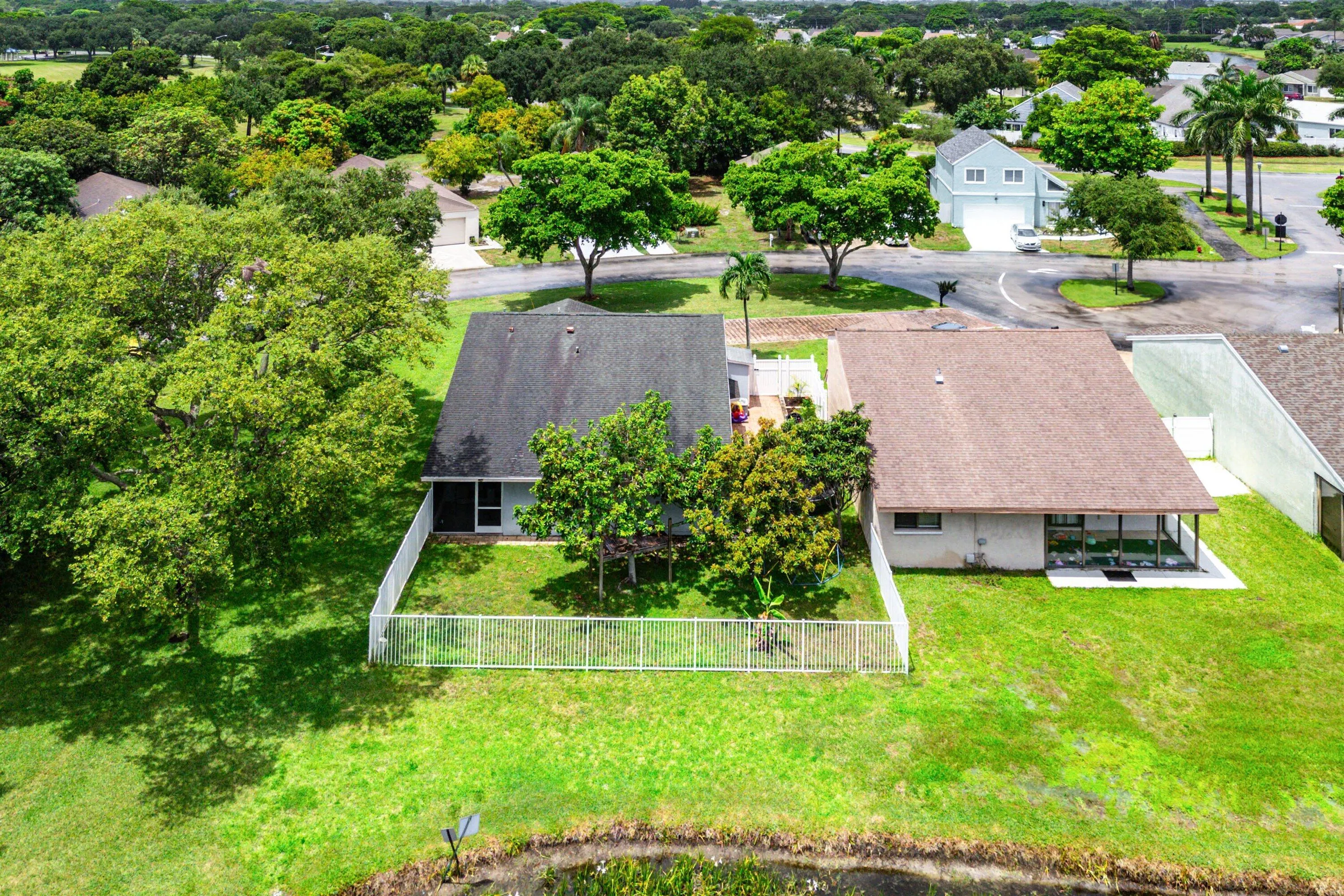 Aerial perspective showcasing two residential properties with lush green landscaping