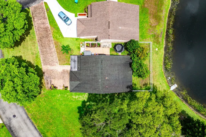 Overhead perspective showcasing a property with a dark shingle roof and a paved driveway