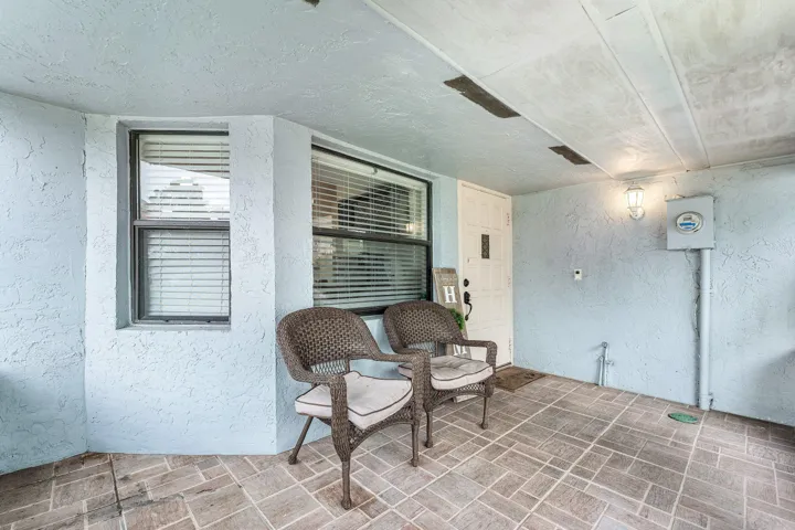 Covered entry with patterned tile flooring and textured walls