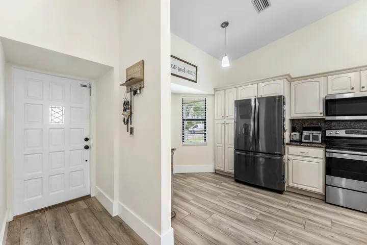Entryway featuring a paneled door with decorative glass inserts and wood-finish flooring