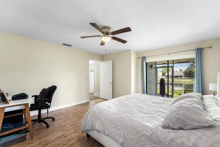 Spacious room featuring wood-finish flooring, a ceiling fan with integrated lighting, and a neutral wall color
