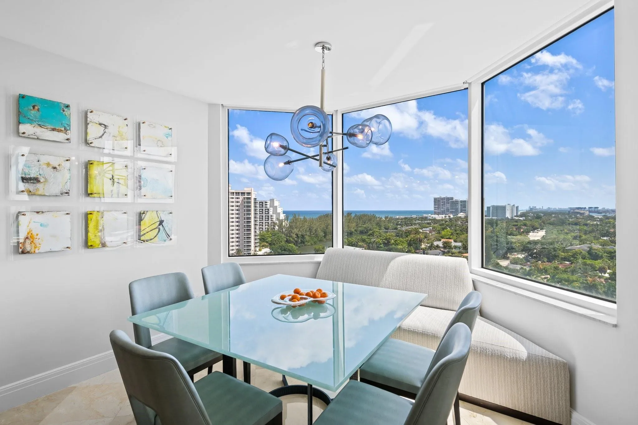 Dining area featuring expansive floor-to-ceiling windows, a built-in banquette, and a modern chandelier