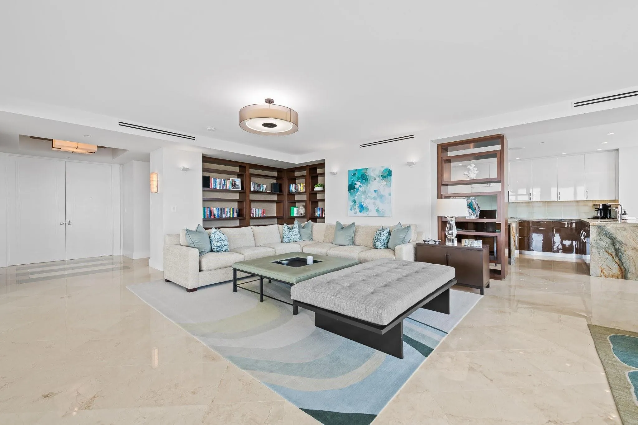 Open-concept living space featuring high ceilings and light-toned tile flooring
