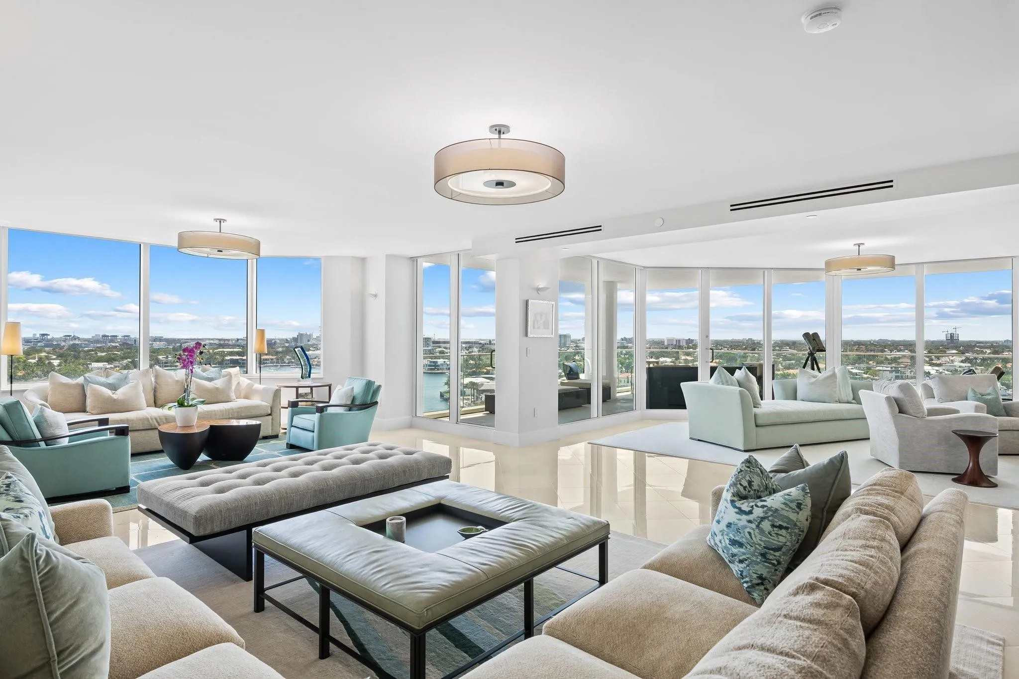 Spacious living area featuring floor-to-ceiling windows, polished tile flooring, and recessed lighting