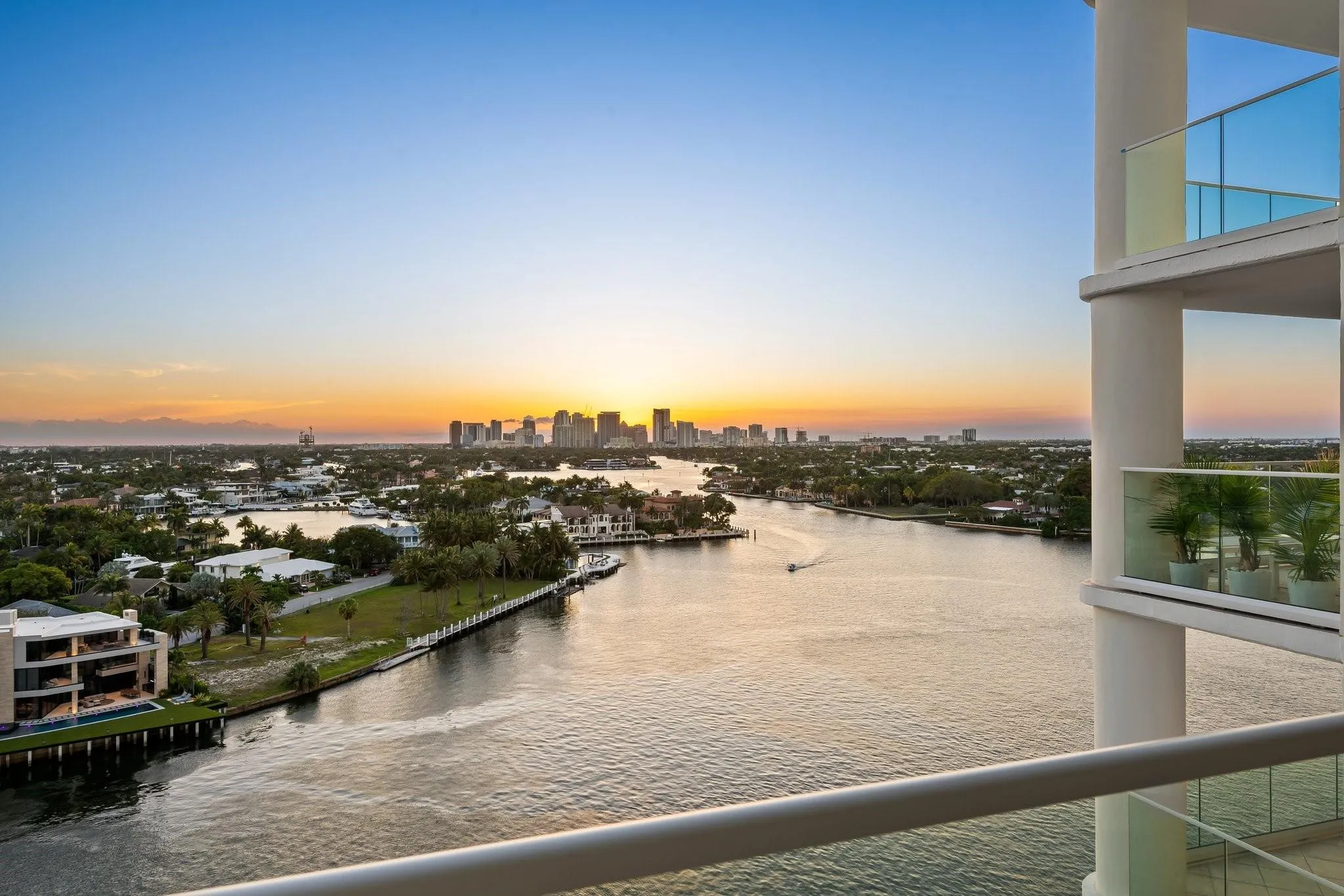 Expansive waterway frontage with a cityscape backdrop at sunset.