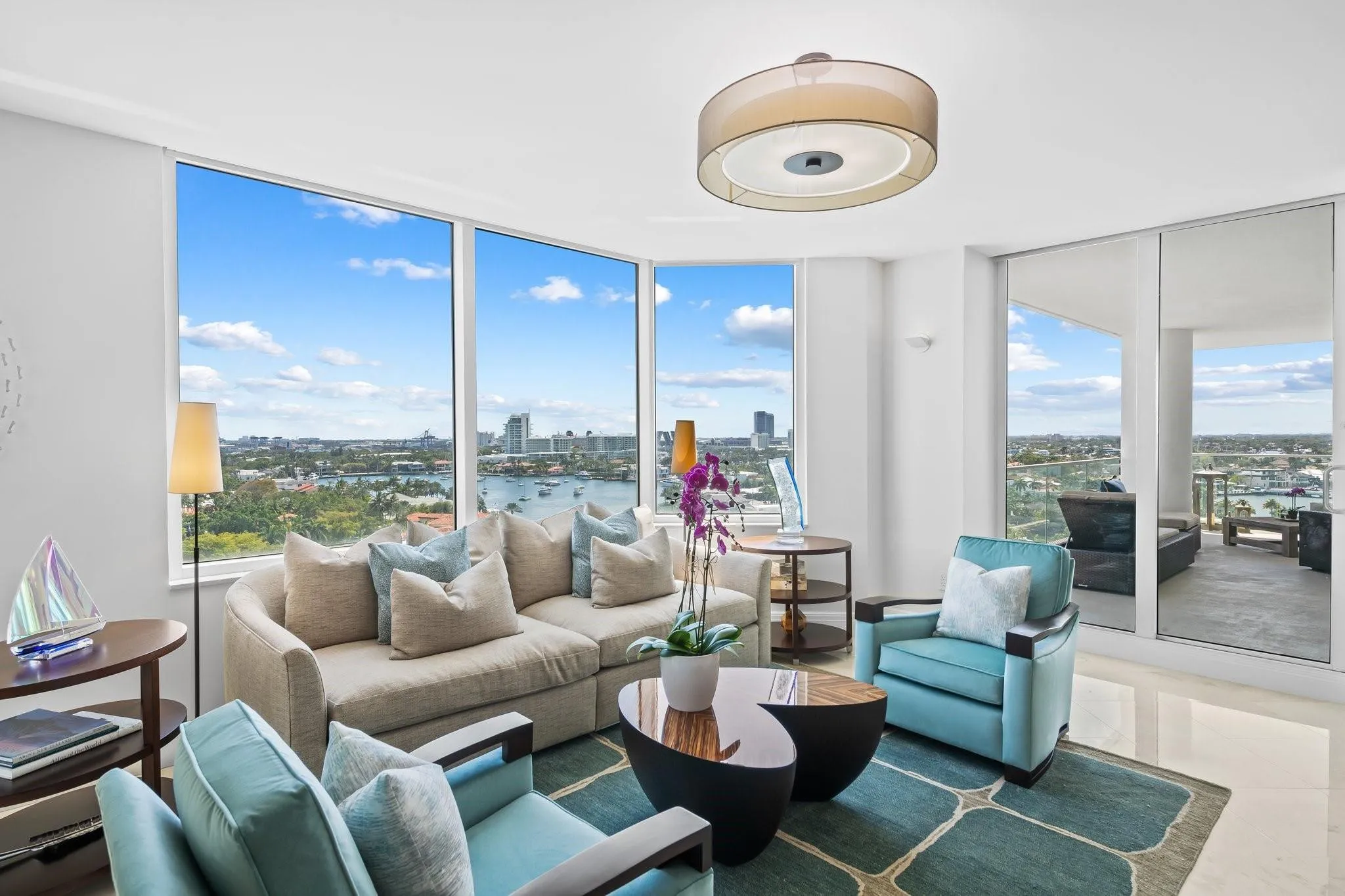 Living area featuring floor-to-ceiling windows, polished tile flooring, a contemporary drum pendant light, and direct access to an outdoor balcony