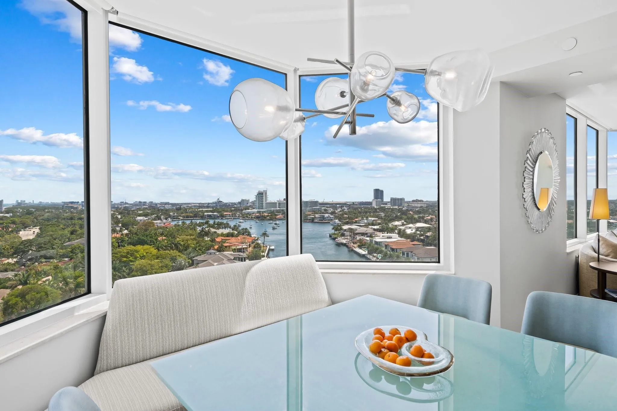 Floor-to-ceiling windows frame the cityscape and waterway