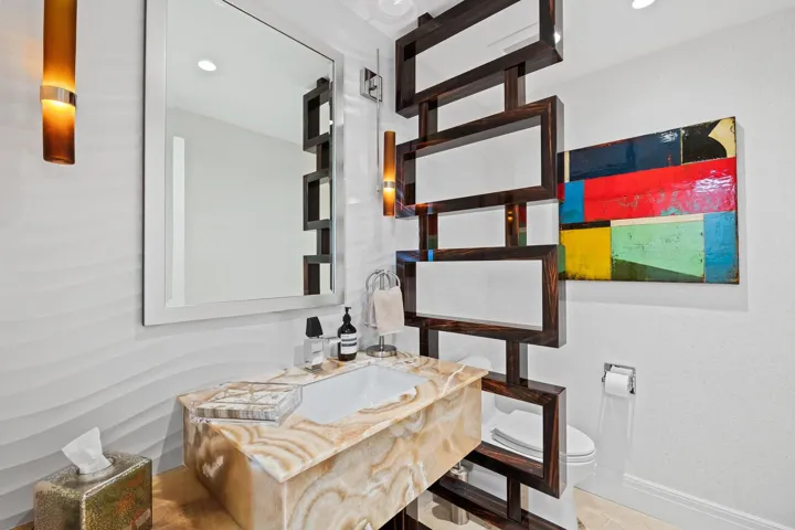 Floating vanity with a built-in rectangular basin, natural stone countertop, and integrated storage