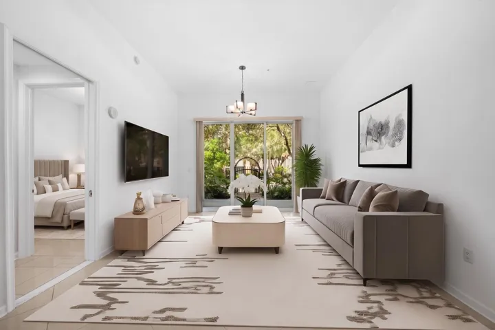 Living area highlighting soaring 11-foot ceilings, tile flooring throughout & sliding glass doors opening to the covered private patio.