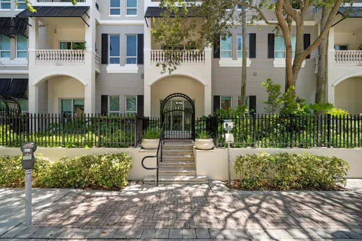 Street-level view of Residence 115N’s private gated entrance, shaded by mature trees along West Las Olas Boulevard.