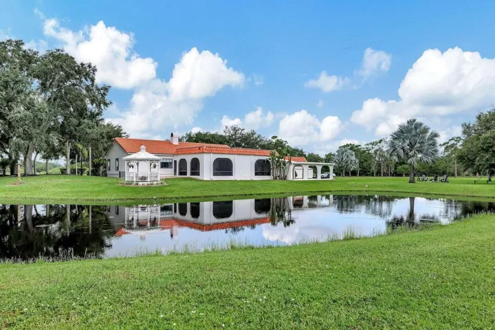 rear view of main house, pond and enclosed patio space