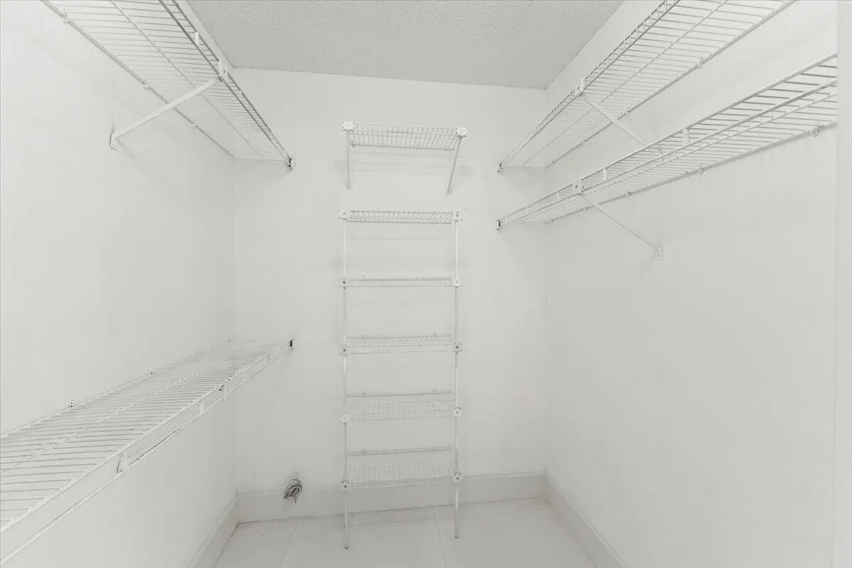 The third bedroom features a small walk-in closet with wire shelves.