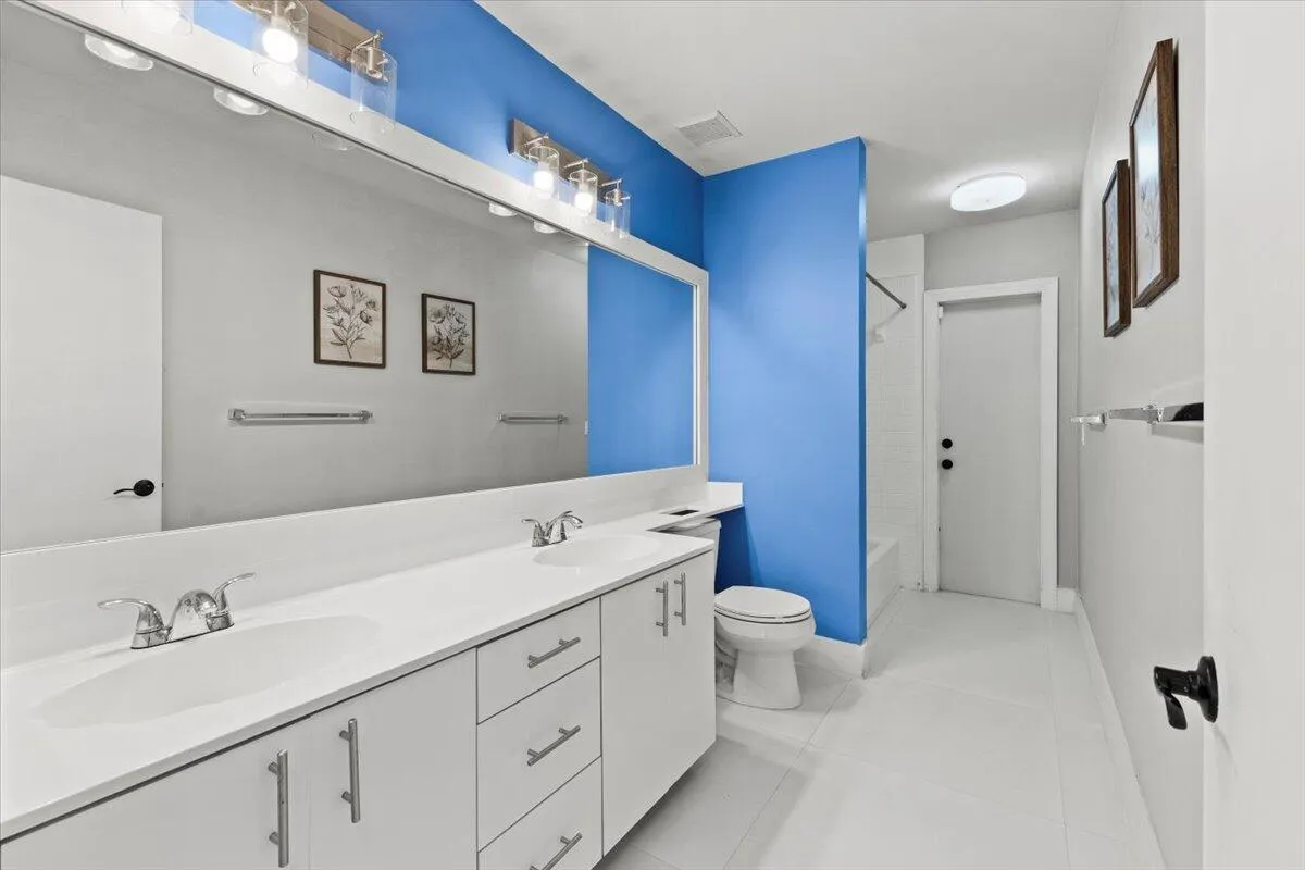 The hall bathroom has a double vanity, shower and tub combination, has a private door leading to the backyard.