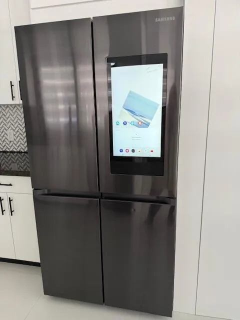 Stainless-steel refrigerator with bottom freezer.