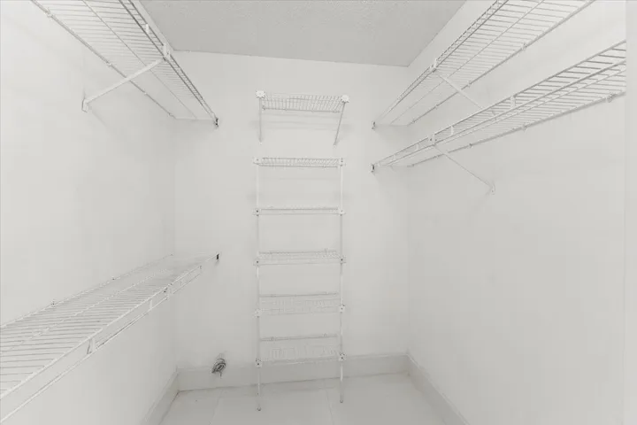 The third bedroom features a small walk-in closet with wire shelves.