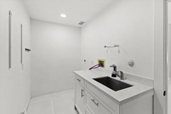 Laundry room featuring washer and dryer hookups, a utility sink, and convenient under sink drawer storage.