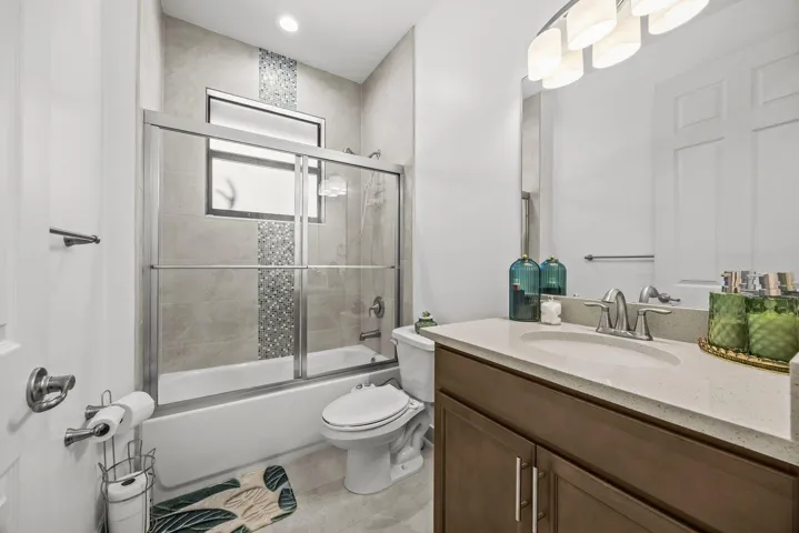 Conveniently appointed with a quartz vanity, tiled tub and shower combination, and contemporary finishes, this full bath is ideal for family, guests, or everyday use.