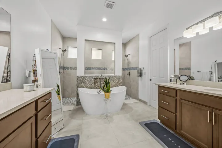 Designed for both beauty and function, the spacious primary bath offers dual vanities, a freestanding soaking tub, and two walk-in showers—creating a comfortable space for busy mornings and relaxing evenings.