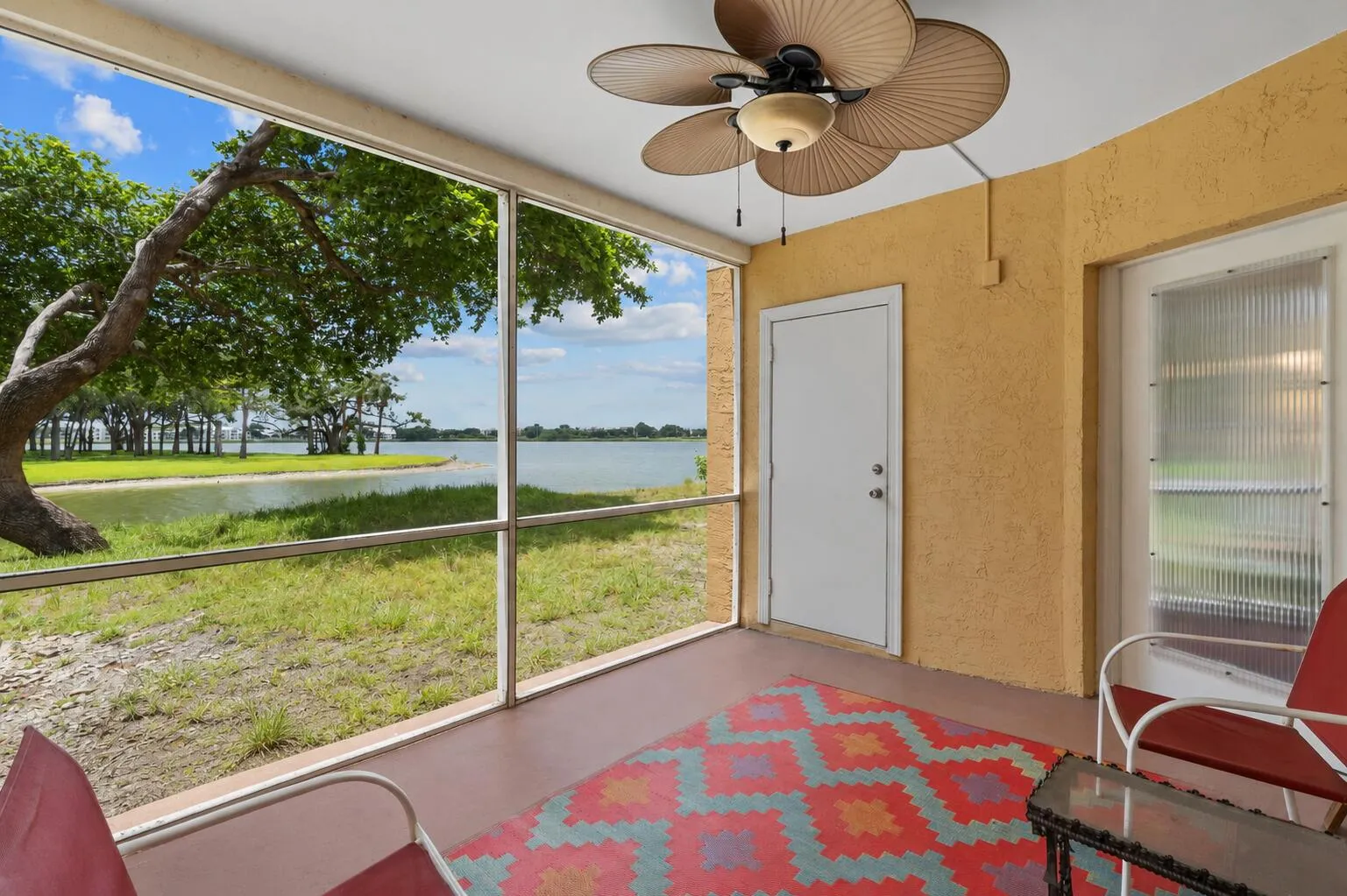 Screened patio provides a comfortable outdoor retreat overlooking the water, complete with a ceiling fan for added comfort.